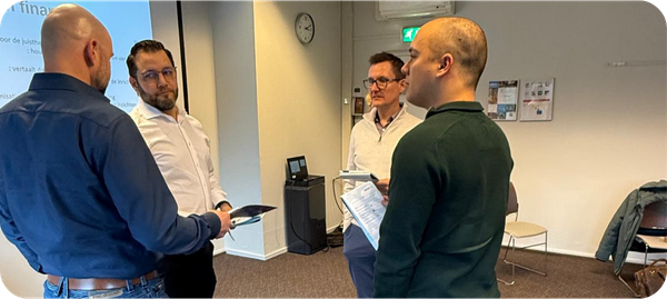 Deelnemers praten met elkaar tijdens een lesdag bij NIVE